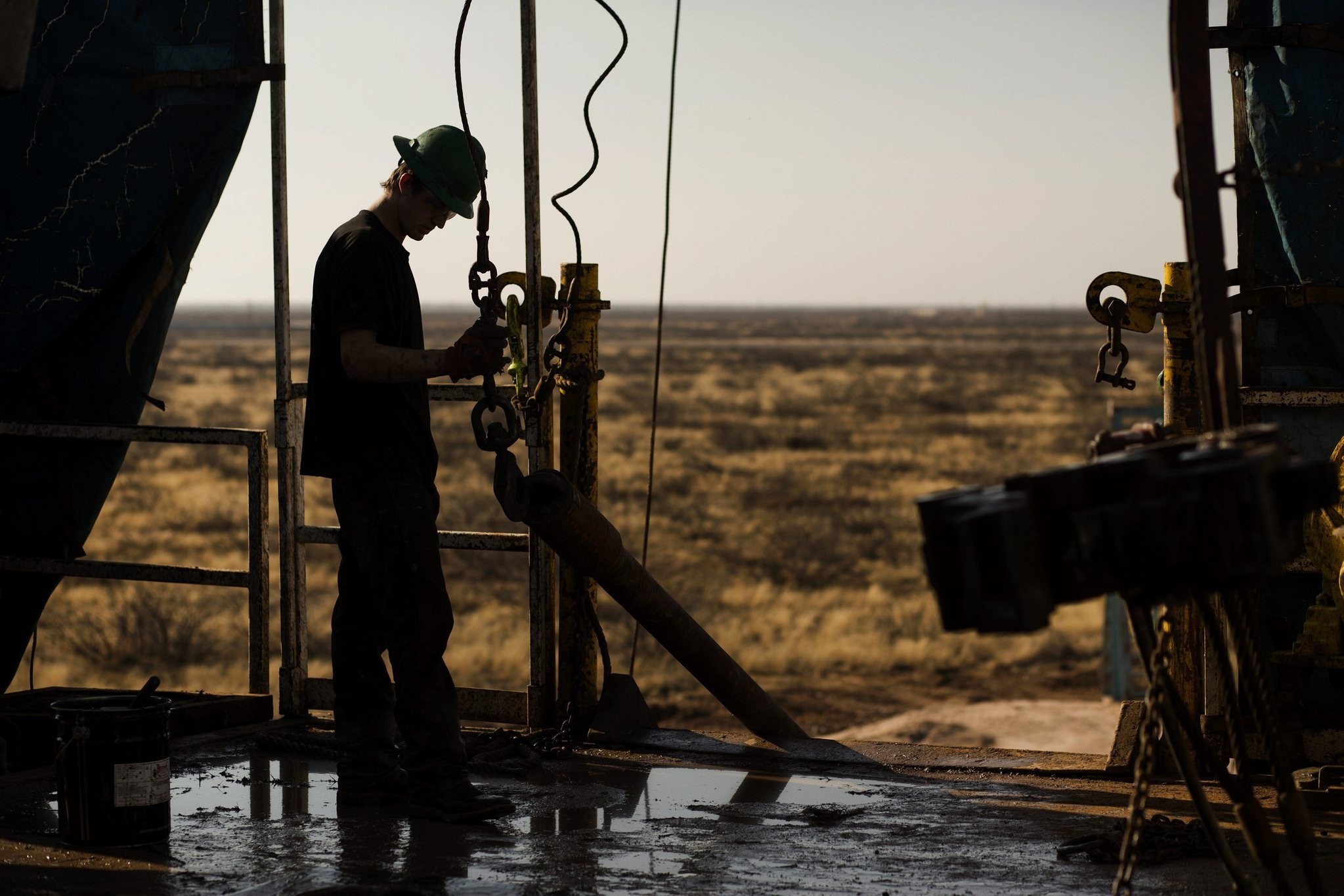 A worker waits to connect a drill bit on Endeavor Energy Resources LP's Big Dog Drilling Rig 22 in the Permian basin outside of Midland, Texas, U.S., on Friday, Dec. 12, 2014.  (Bloomberg Photo)