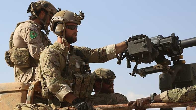 The US soldier on the left is seen wearing a YPJ badge in this picture. (AFP Photo)