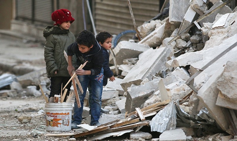 Children collect firewood amid damage and debris at a site hit yesterday by airstrikes in the rebel held al-Shaar neighbourhood of Aleppo, Syria November 17, 2016 (Reuters Photo)