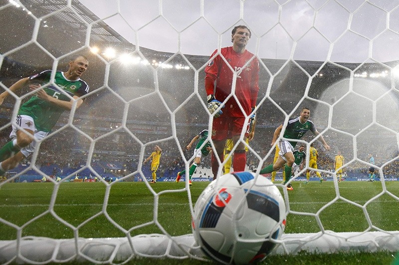 Northern Ireland's defender Jonny Evans (L) celebrates the opening goal scored by Northern Ireland's defender Gareth McAuley past Ukraine's goalkeeper Andriy Pyatov (AFP Photo)
