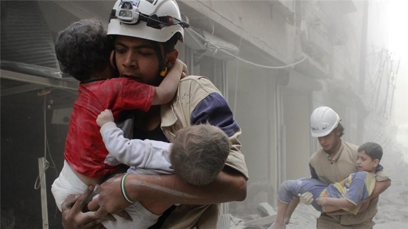 A White Helmets volunteer hurries to take the wounded children to a hospital. 