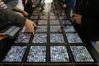 Developers look over new apps displayed on iPads at the Apple Worldwide Developers Conference in San Francisco.