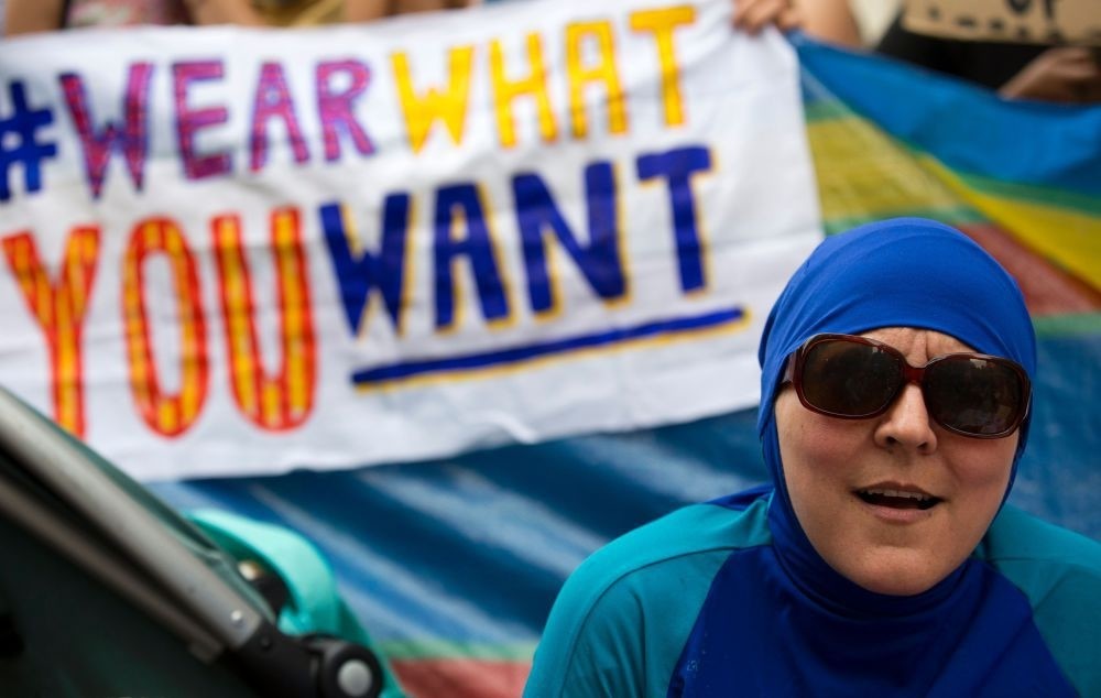 Woman wearing a burkini joins a protest outside the French Embassy in London.