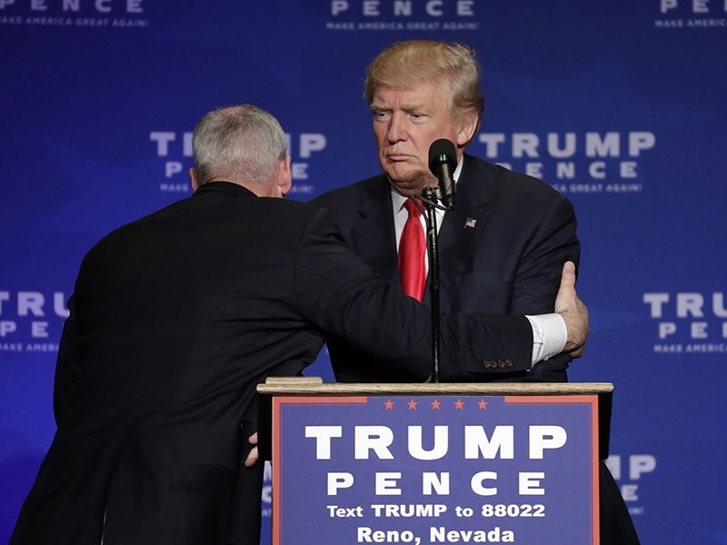 A member of the Secret Service pulls Republican presidential candidate Donald Trump from the stage at a campaign rally in Reno, Nev.. (AP Photo)