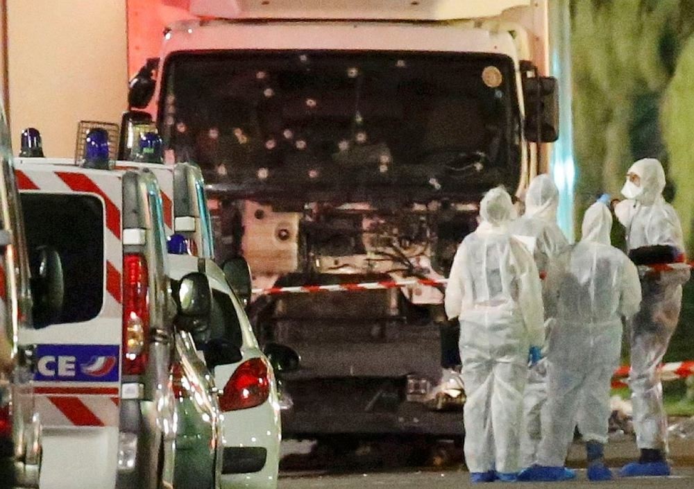 French police forces and forensic officers stand next to a truck July 15, 2016 that ran into a crowd celebrating the Bastille Day national holiday on the Promenade des Anglais killing at least 60 people in Nice, France, July 14. (Reuters Photo)