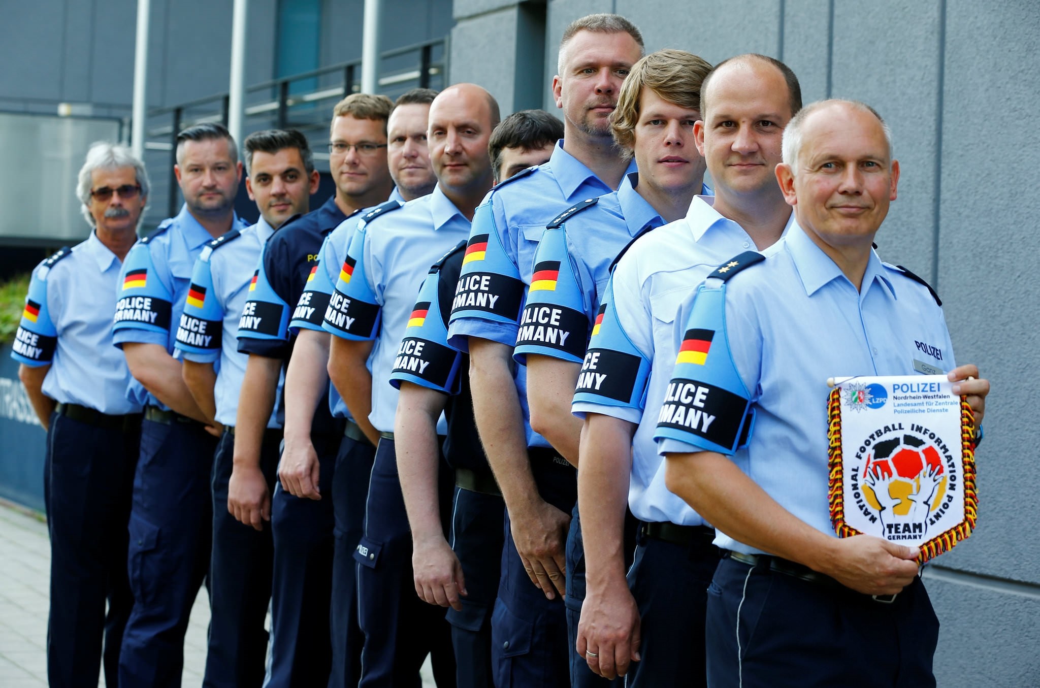 German police officers pose for an image with their armband reading ,Police Germany, at the North Rhine-Westphalian police headquarters in Duisburg, Germany, June 6, 2016. 