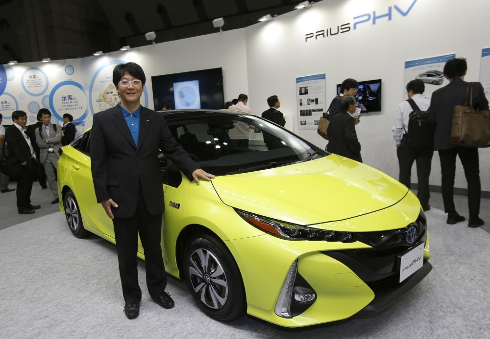 Chief Engineer Kouji Toyoshima poses with a Prius PHV at the Smart Community Japan exhibition in Tokyo.