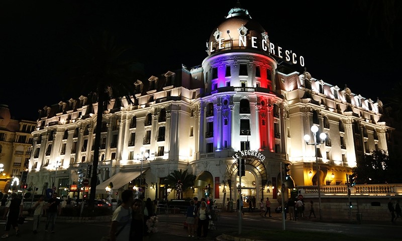This photo taken on July 17, 2016 on the Promenade des Anglais in Nice shows the Hotel Negresco illuminated in the colours of France's flag in tribute to the victims of the Bastille Day attack (AFP Photo)