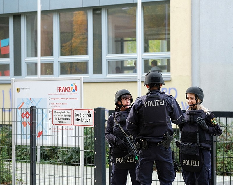 Police stand in front of the Reclam High School in Leipzig after the school received threats of violence by email, Germany, Oct. 17, 2016. (AP Photo)
