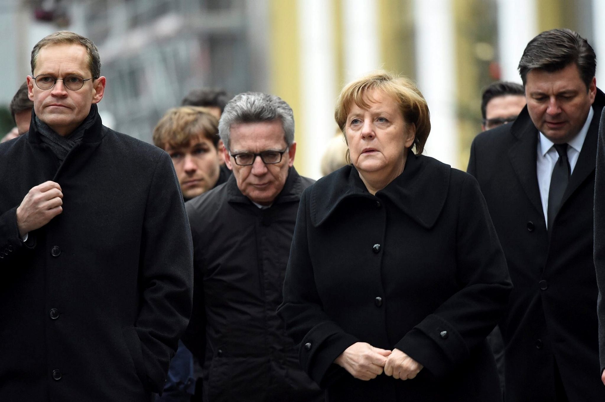 Berlin Mayor Michael Mueller (L), German Interior Minister Thomas de Maiziere (C) and German Chancellor Angela Merkel (R) visit the scene of an attack on a Christmas market in Berlin, Germany.