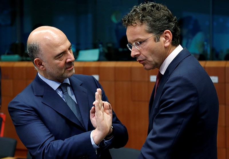 European Economic and Financial Affairs Commissioner Pierre Moscovici talks to Dutch Finance Minister and Eurogroup President Jeroen Dijsselbloem (R) during an euro zone finance ministers meeting. (REUTERS Photo)