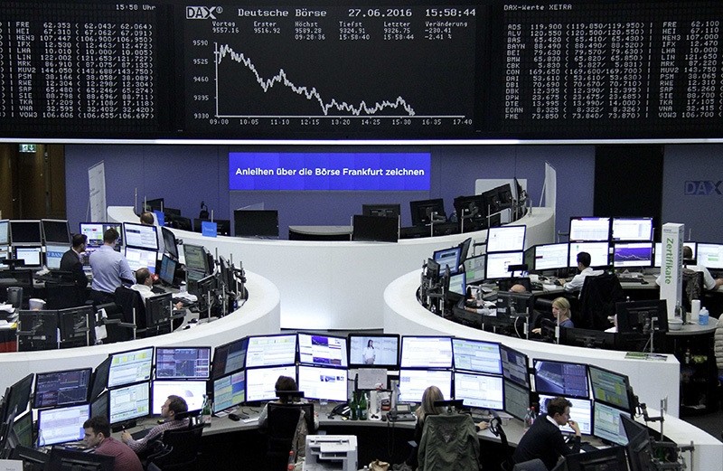 Traders work at their desks in front of the German share price index, DAX board, at the stock exchange in Frankfurt, Germany, June 27, 2016. (Reuters Photo)