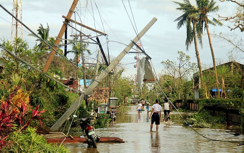 Residents walk past partially toppled electric posts after Typhoon Nock Ten hit Malinao, Albay in central Philippines December 26, 2016. (Reuters Photo)