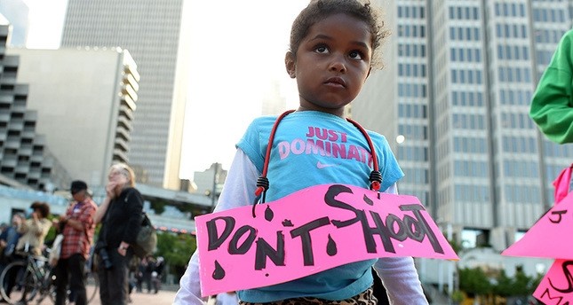 Nimani Darch-Walker, 3, wearing a sign that reads ,Don't Shoot,, looks on during a rally by the Black Lives Matter movement at Justin Herman Plaza in San Francisco, California on July 8, 2016. (AFP Photo)