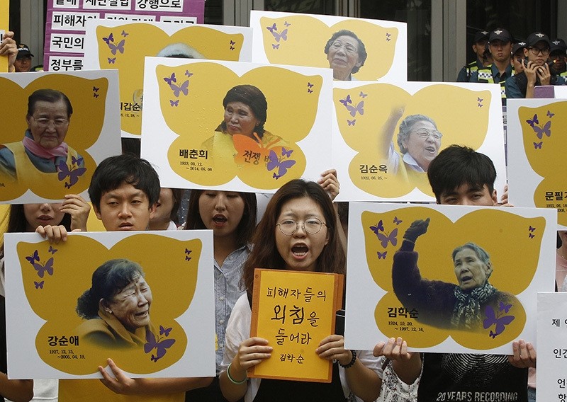 In this July 28, 2016 file photo, protesters hold the portraits of the former sex slaves who were forced to serve for the Japanese military in WWII, during a rally against the Reconciliation and Healing Foundation in Seoul, South Korea. (AP Photo)