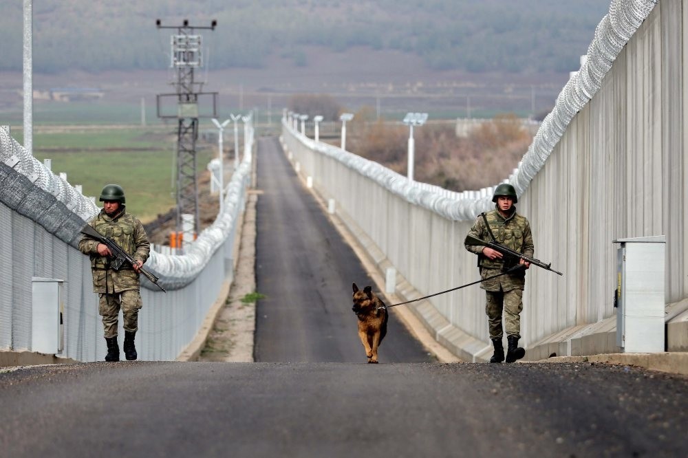 Troops patrol a completed part of the wall that stretches along the border.