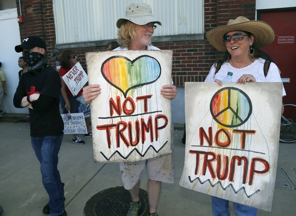 Dallas residents David Lyles (L) and Cynthia Seely (R) holding protest signs on Lamar Street outside a rally for Republican presidential candidate Donald Trump at Gilley's on June 16, 2016 in Dallas.