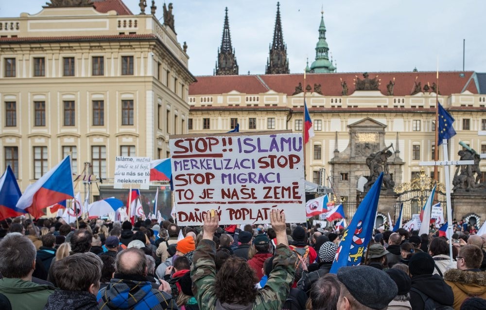 A protester holding up a sign written in Czech that reads, ,Stop Islam and stop Merkel,, during an anti-Islam rally in front of the Prague Castle in Prague, Czech Republic, Feb. 6, 2016.