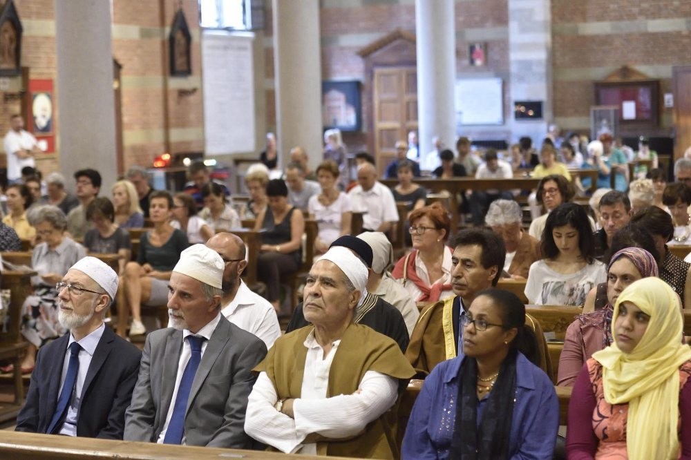 Members of the congregation in Santa Maria Caravaggio Church in Milan during a multi faith service organized by Italy's Islamic Religious Community (COREIS), July 31.