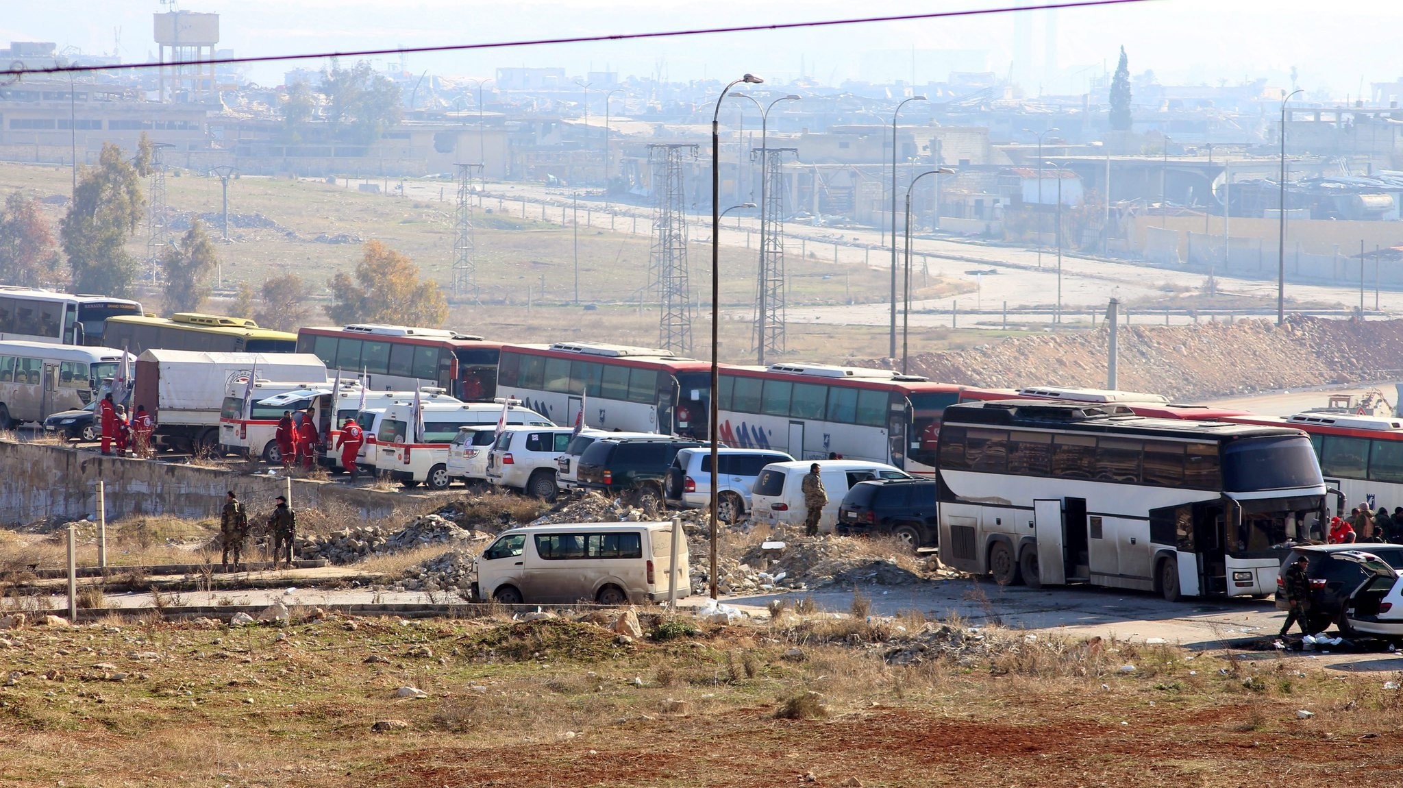 Buses wait to evacuate a group of fighters and their families from eastern neighborhoods of Aleppo, Syria, 19 December 2016. (EPA Photo)