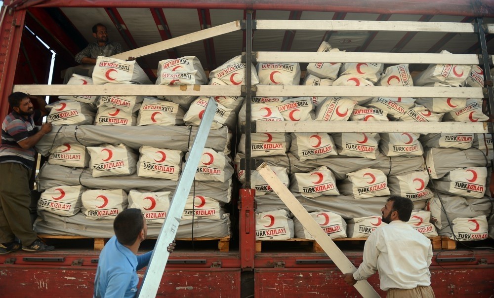 Workers unload aid boxes in Irbil, Iraq. Turkey dispatched 20 trucks of aid for the displaced in the country.