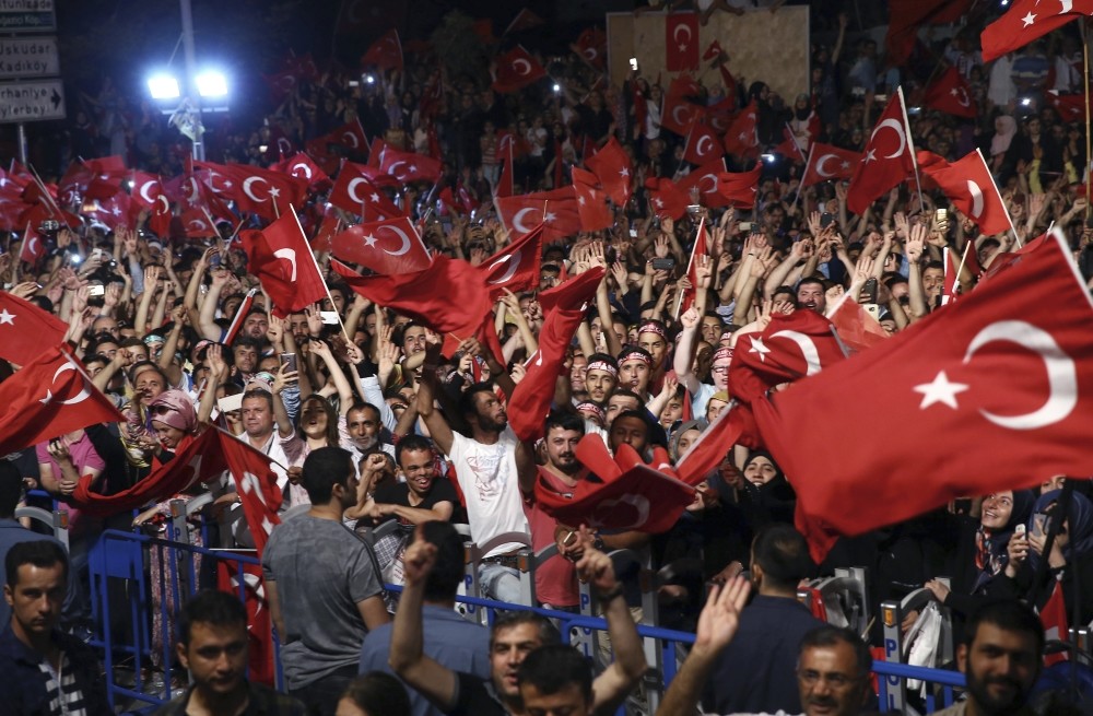 People listening to President Erdou011fan as he addresses them in front of his residence in Istanbul, July 19.