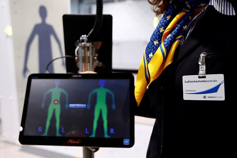 An employee of a private security firm at the Cologne-Bonn Konrad Adenauer Airport demonstrates a full-body scan at the world's pilot innovative ,Easy Security, system for passengers in Cologne (Reuters Photo)
