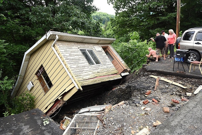 Employees and volunteers with Main Street Motors attempt to get company documents out of the building Friday June 24, 2016, in Richwood, W.Va., after the company's building was knocked off its foundation by extensive flooding. (AP Photo)