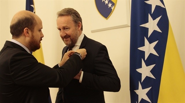 Bilal Erdou011fan (L) pins a badge on member of the presidency of Bosnia and Herzegovina Bakir Izetbegovic's suit, in Sarajevo, on May 27, 2015 