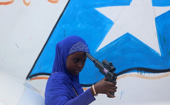 A Somali girl plays with a toy gun after attending Eid al-Fitr prayers to mark the end of the fasting month of Ramadan in Somalia's capital Mogadishu, July 6, 2016. (Reuters Photo)