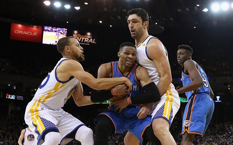 Russell Westbrook #0 of the Oklahoma City Thunder is guarded by Stephen Curry #30 and Zaza Pachulia #27 of the Golden State Warriors at ORACLE Arena on January 18, 2017 in Oakland, California. (AFP Photo)