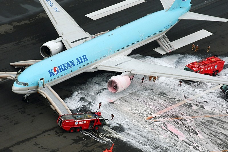 An aerial picture shows firefighters spraying foam at the engine of a Korean Air Lines plane after smoke rose from it at Haneda airport in Tokyo, Japan, May 27, 2016. (Kyodo Photo via Reuters)