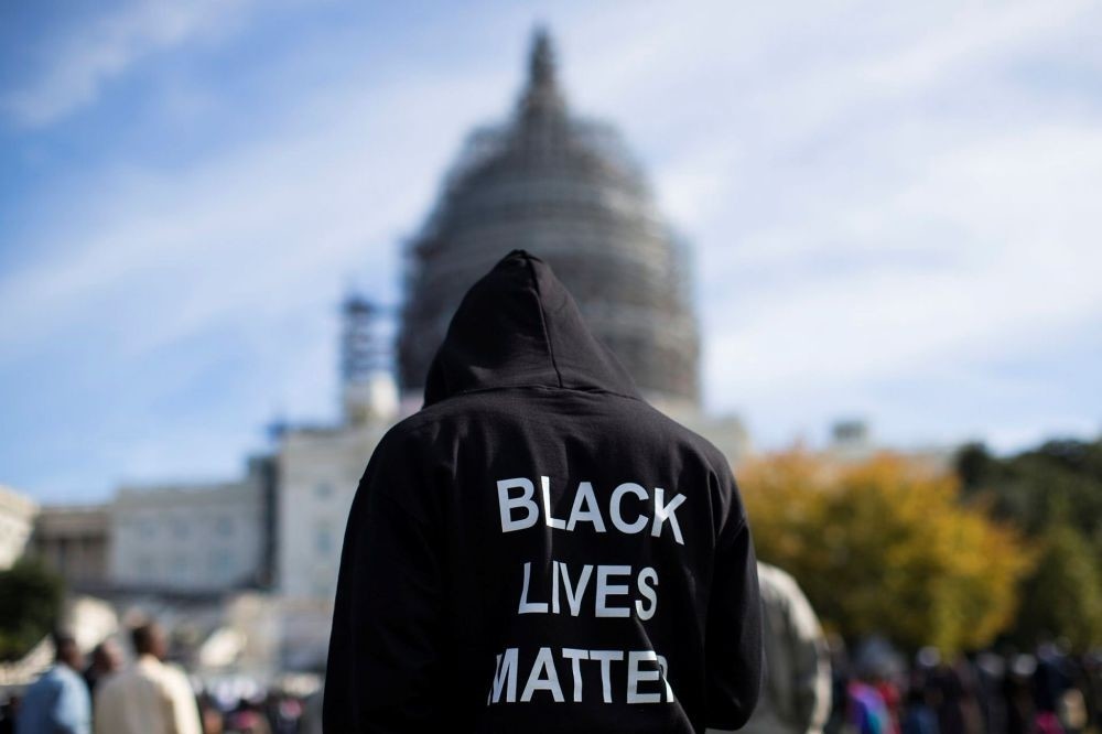 A man wears a hoodie that reads, ,Black Lives Matter, standing on the lawn of the Capitol building on Capitol Hill in Washington during a rally to mark the 20th anniversary of the Million Man March. (AP Photo)