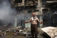 An Iraqi man shouts after a bomb destroyed his home in Baghdad.