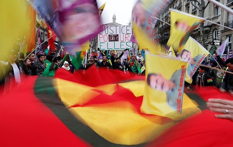 PKK supporters hold flags which portray Abdullah u00d6calan, leader of the terror group. (Reuters Photo)