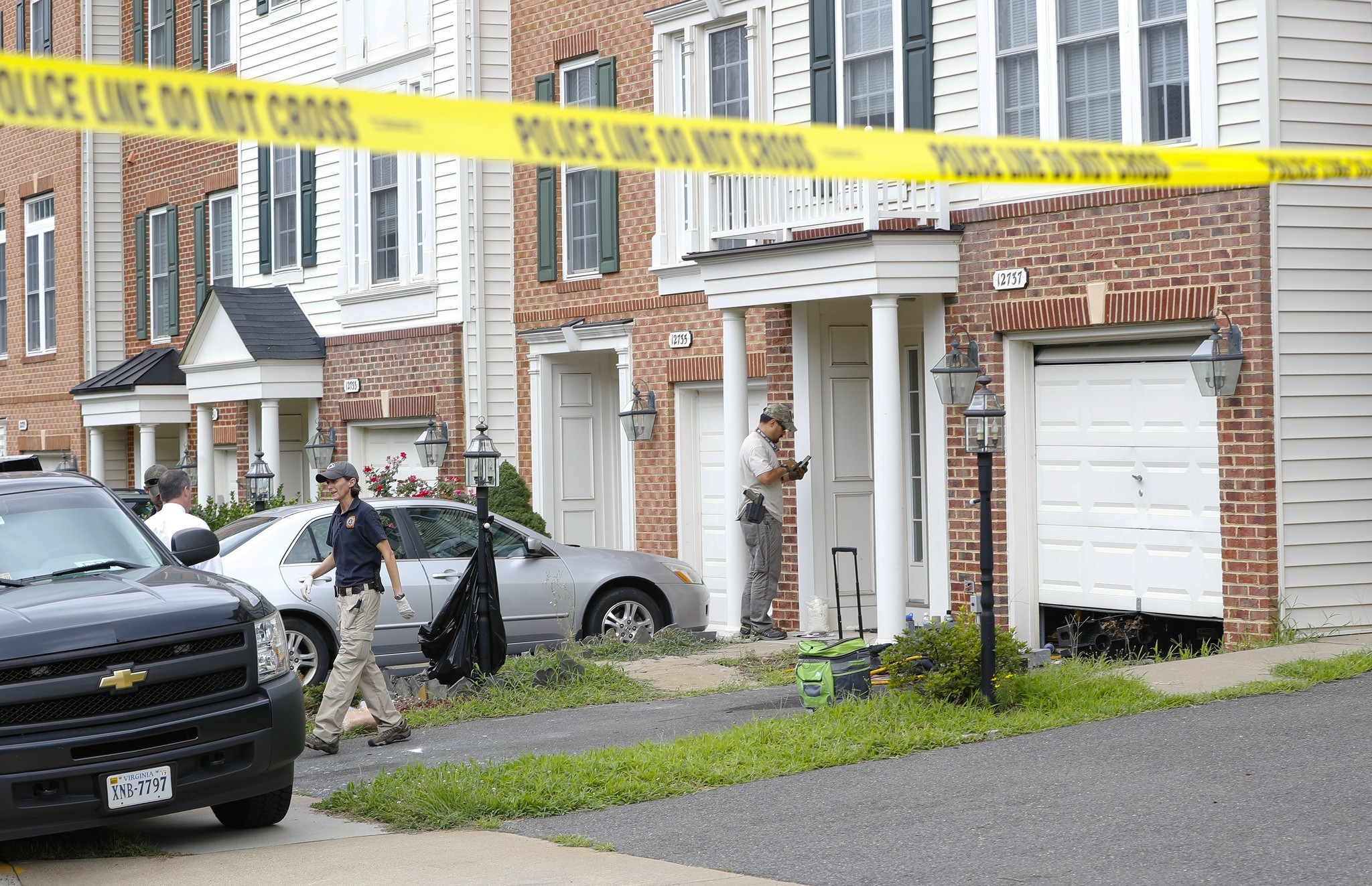 Law enforcement officers are seen outside the home of Nicholas Young, a Washington Metro Transit Officer, Wednesday, Aug. 3, 2016, in Fairfax, Va. (AP Photo)