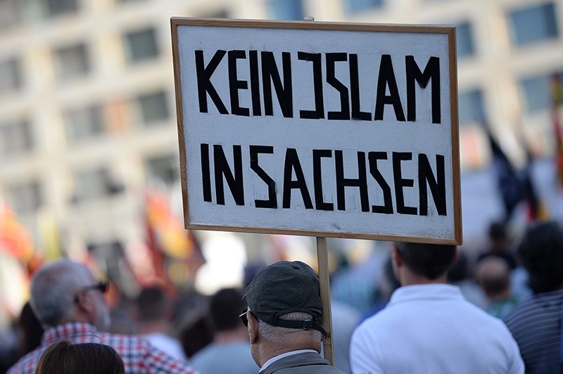 A participant carries a placard reading; 'No Islam in Saxony', during PEGIDA rally in Dresden, Germany, 30 May 2016. (EPA)