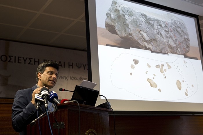 Greek archaeologist Christofilis Maggidis speaks as a photograph of a stone he believes belonged to the lost royal throne in the ancient palace of Mycenae, in Athens, on Tuesday, June 14, 2016. (AP Photo)