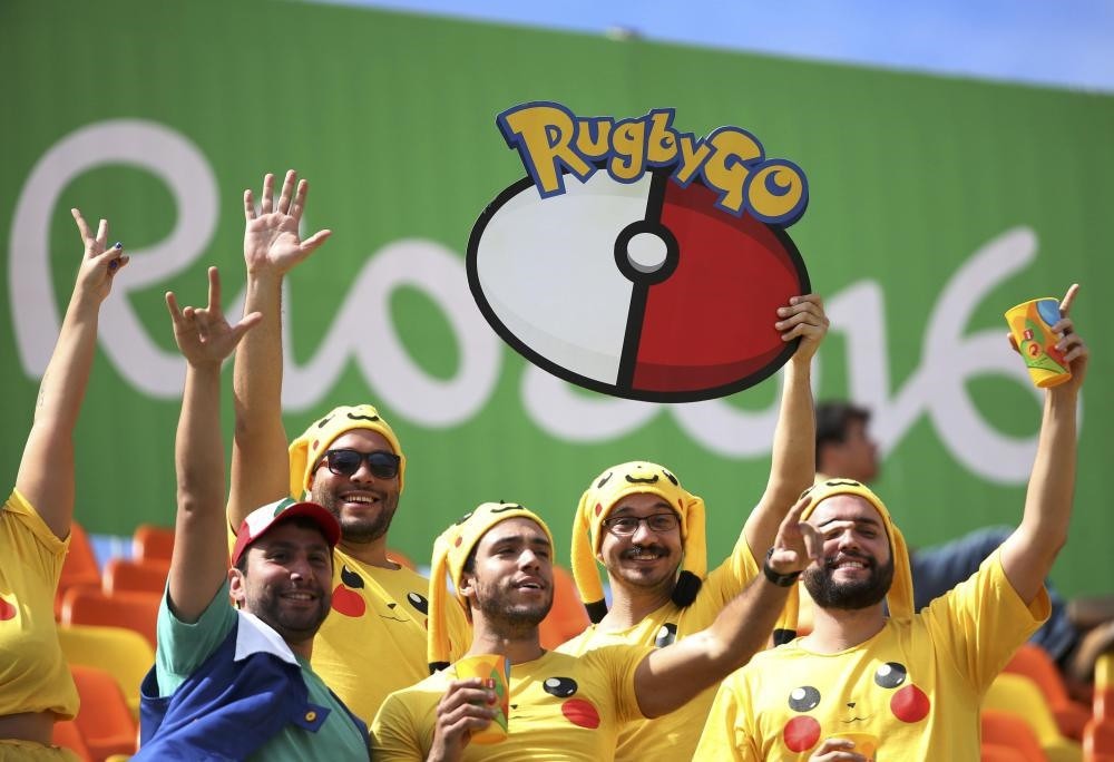 Rugby fans dressed as Pikachu from u201cPokemon Gou201d watch from the stands.