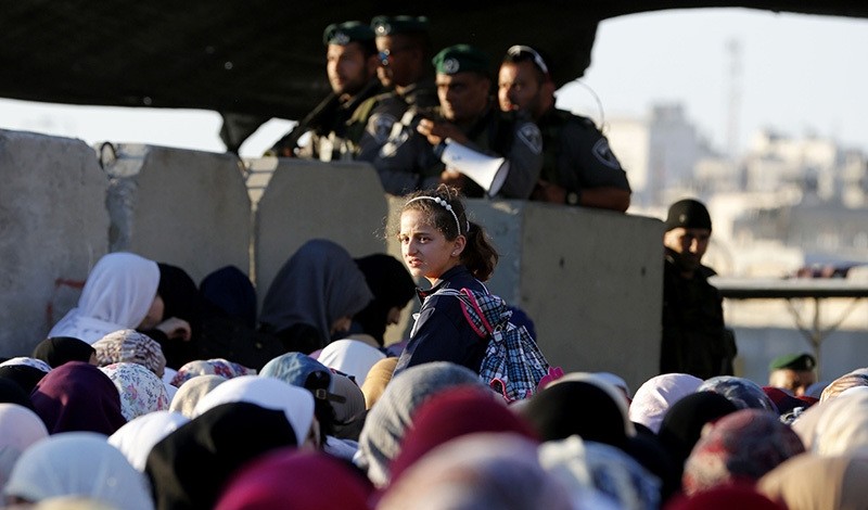 Palestinians wait to cross the Israeli Qalandia checkpoint as Muslim worshippers make their way to attend the second Friday prayer of the holy fasting month of Ramadan in Jerusalem's al-Aqsa mosque compound, on June 17, 2016 (AFP Photo