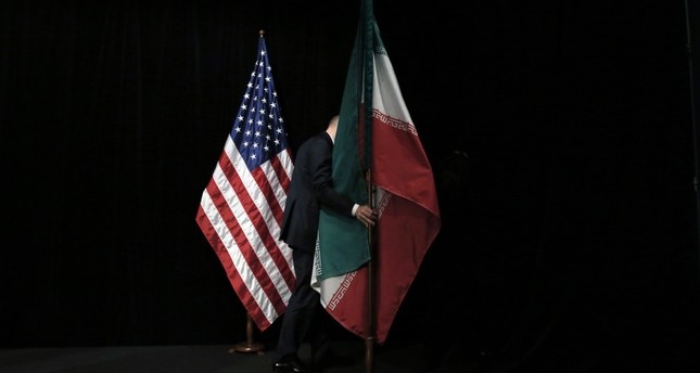 A staff member removes the Iranian flag from the stage after a group picture with foreign ministers and representatives of United States and P5 countries has taken during the Iran nuclear talks at the Vienna International Center in Vienna.