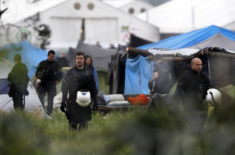 Greek policemen inspect the tents at a makeshift refugee camp at the Greek-Macedonian border near the northern village of Idomeni, Tuesday, May 24, 2016. (AP Photo)