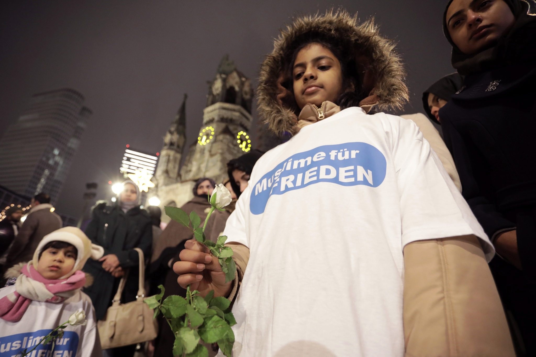 Participants in a vigil wear t-shirts with the slogan 'Muslims for Peace' outside the Kaiser Wilhelm Gedaechtnis Church in Berlin, 20 Dec 2016. (EPA Photo) 