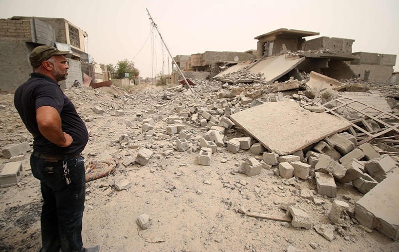 A member of the Iraqi counter terrorism forces inspects collapsed buildings in Fallujah's southern Shuhada neighbourhood after Iraqi govu2019t forces retook the area from Daesh on June 18, 2016 (AFP Photo)