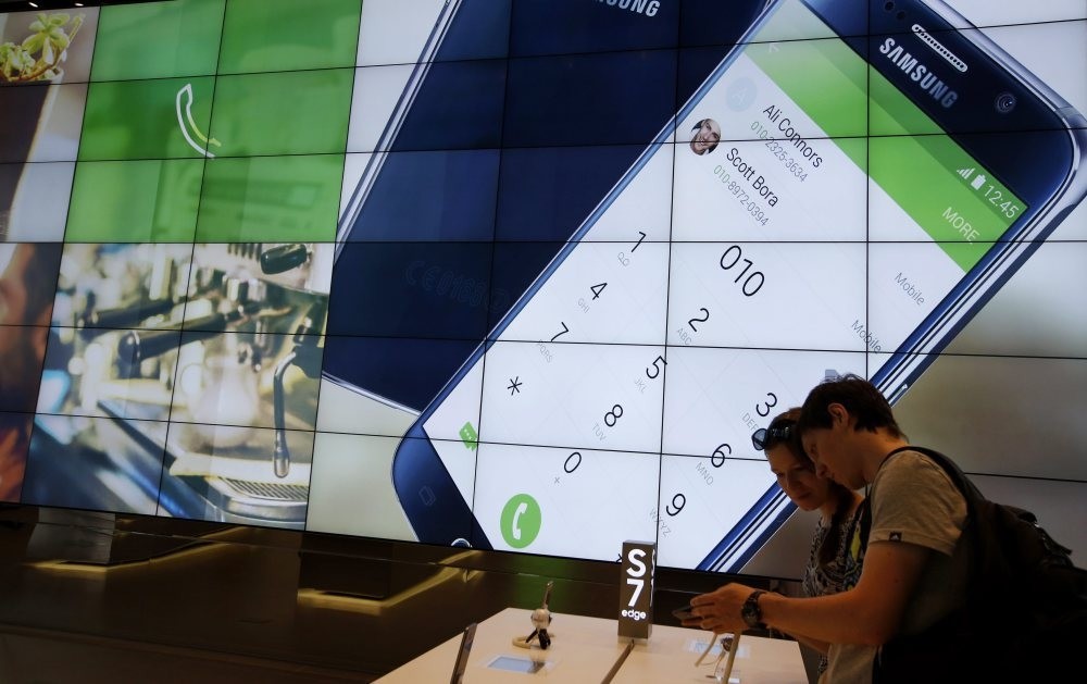 Foreign visitors look at a Samsung Galaxy S7 and a Galaxy S7 Edge smartphones in a showroom at the SamsungElectronics headquarters in Seoul. (EPA Photo)