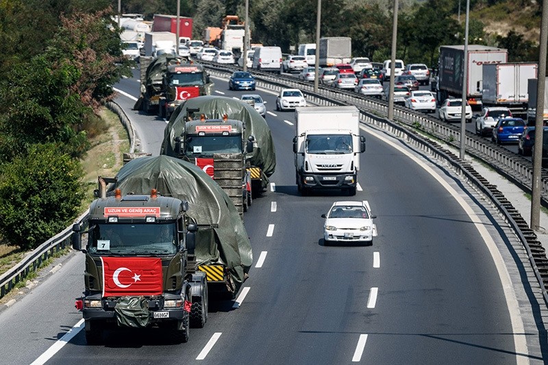 Military trucks with the Turkish national flag transport tanks as they drive on a highway out of Istanbul on August 22, 2016. (AFP Photo)