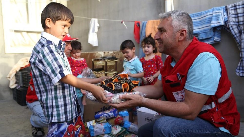 A Turkish Red Crescent worker delivers aid to Iraqi children. The Red Crescent was among the sponsors of the forum, where redefining priorities for humanitarian aid was discussed. 