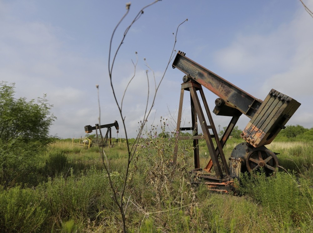 Pumps sit idle on a South Texas ranch. Deserted drilling wells are the relics of every oil bust, and Texas is pitted with more than any other place in the U.S.