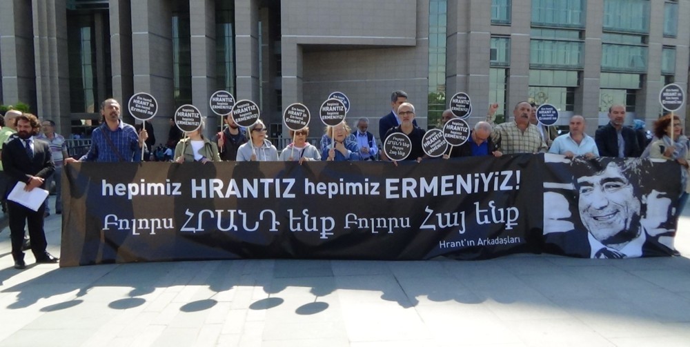 Activists hold a banner with a photo of Hrant Dink and a slogan: ,We are all Hrant,, outside the courthouse in Istanbul.