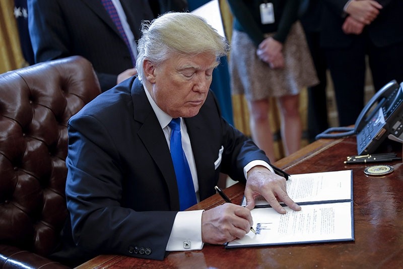 US President Donald Trump signs one of five executive orders related to the oil pipeline industry in the oval office of the White House in Washington, DC, USA, 24 January 2017. (EPA Photo)